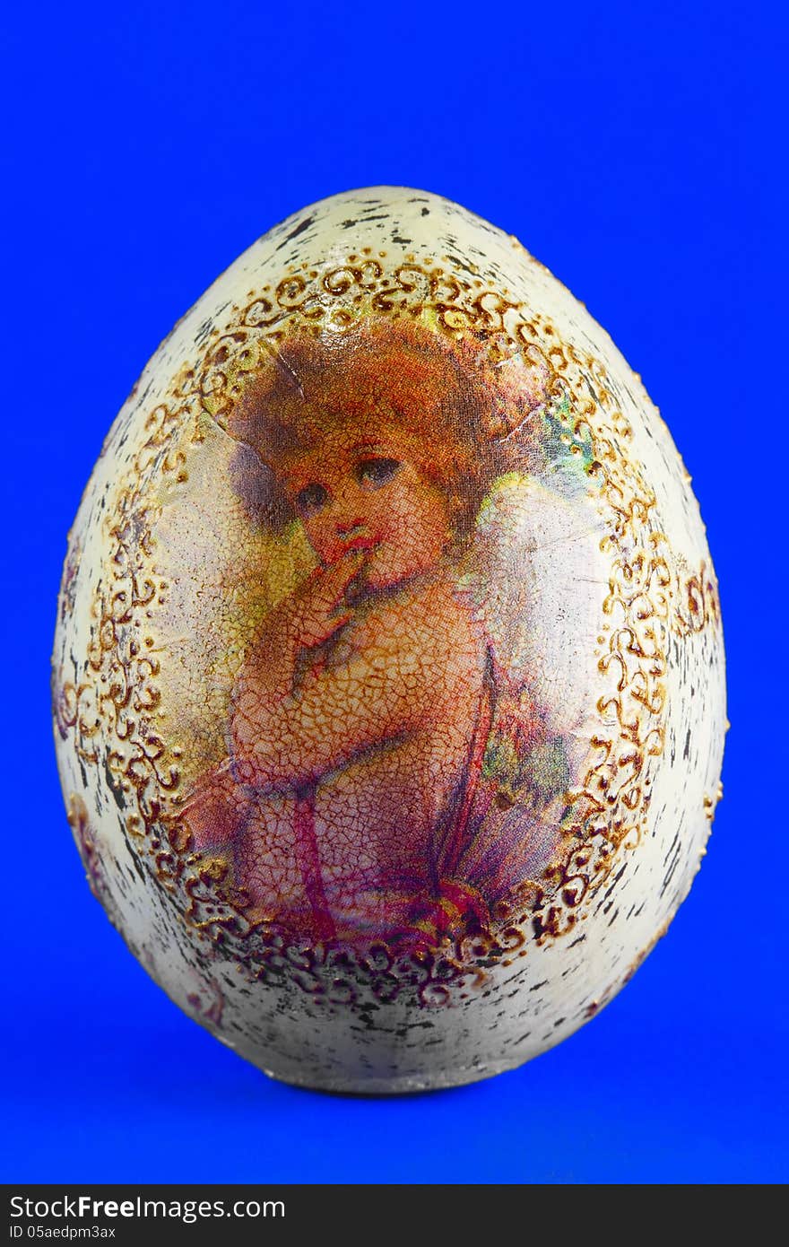 Easter egg with the image of an angel, close up, blue background