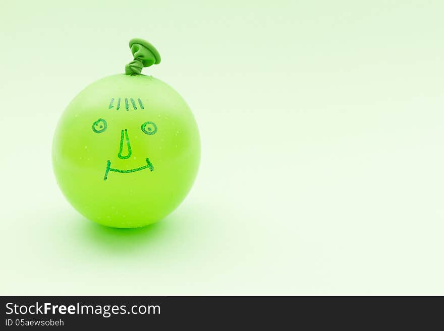 Drawing smile on inflated green baloon. Drawing smile on inflated green baloon