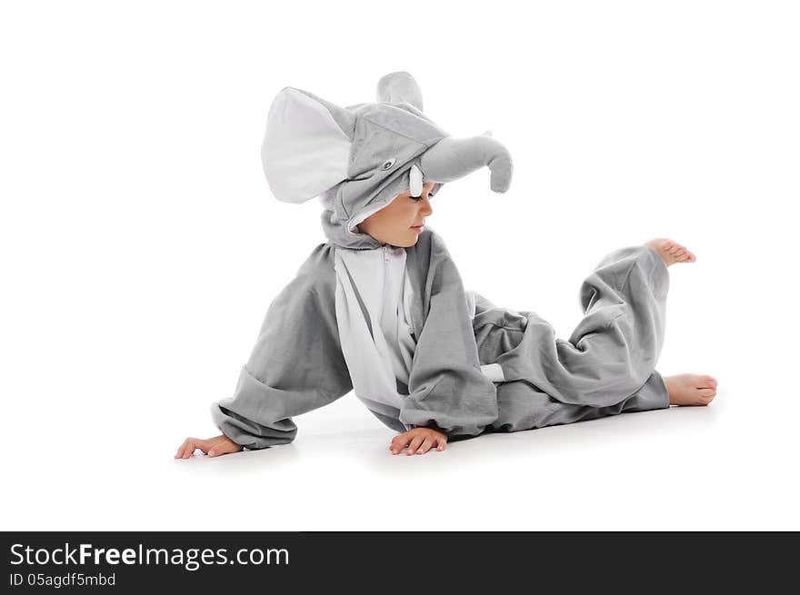 Cute boy dressed in elephant costume lying on the floor.