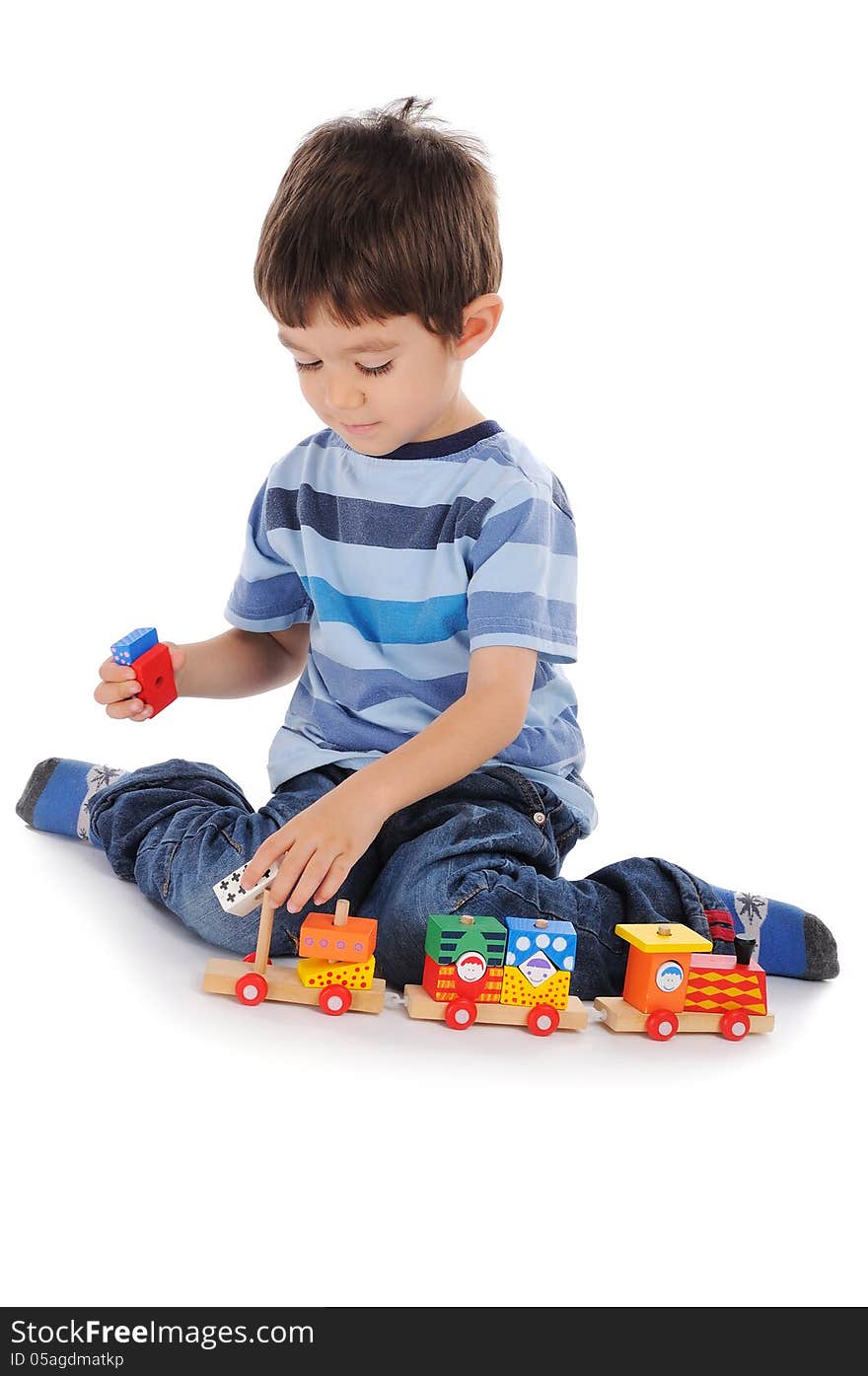 Little boy is making a train of wooden colorful pieces. Little boy is making a train of wooden colorful pieces.