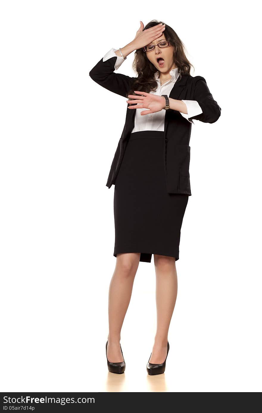 Worried business woman looking at the clock on white background