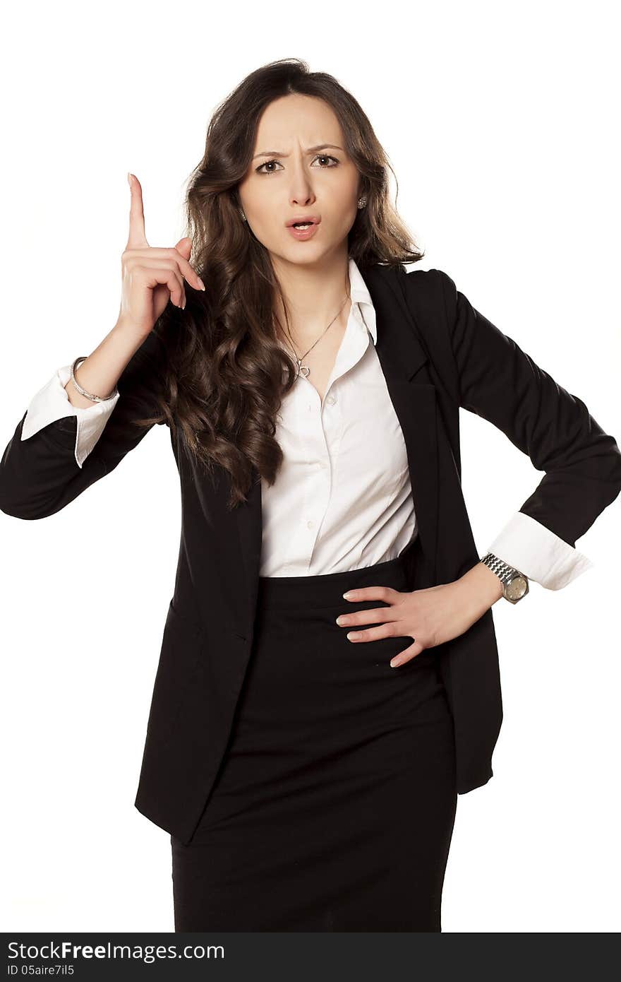 Frowning and angry business woman pointing a finger upwards