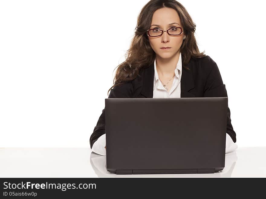 Serious girl with glasses working on laptop on white background