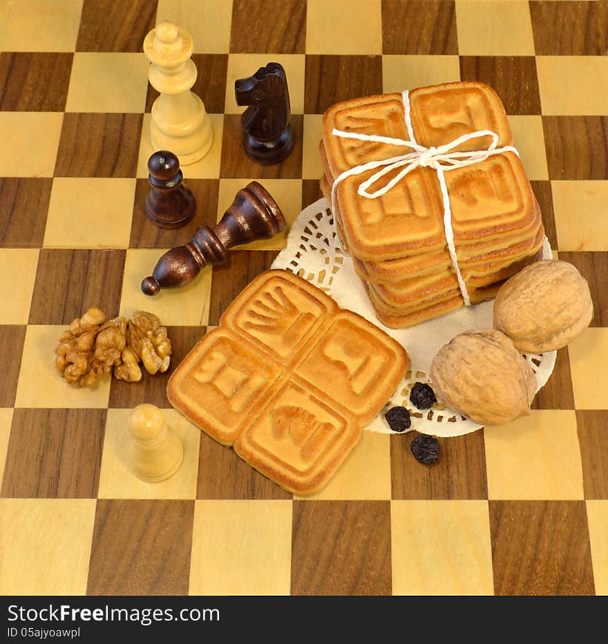 Yellow cookies with nuts on the chessboard. Yellow cookies with nuts on the chessboard