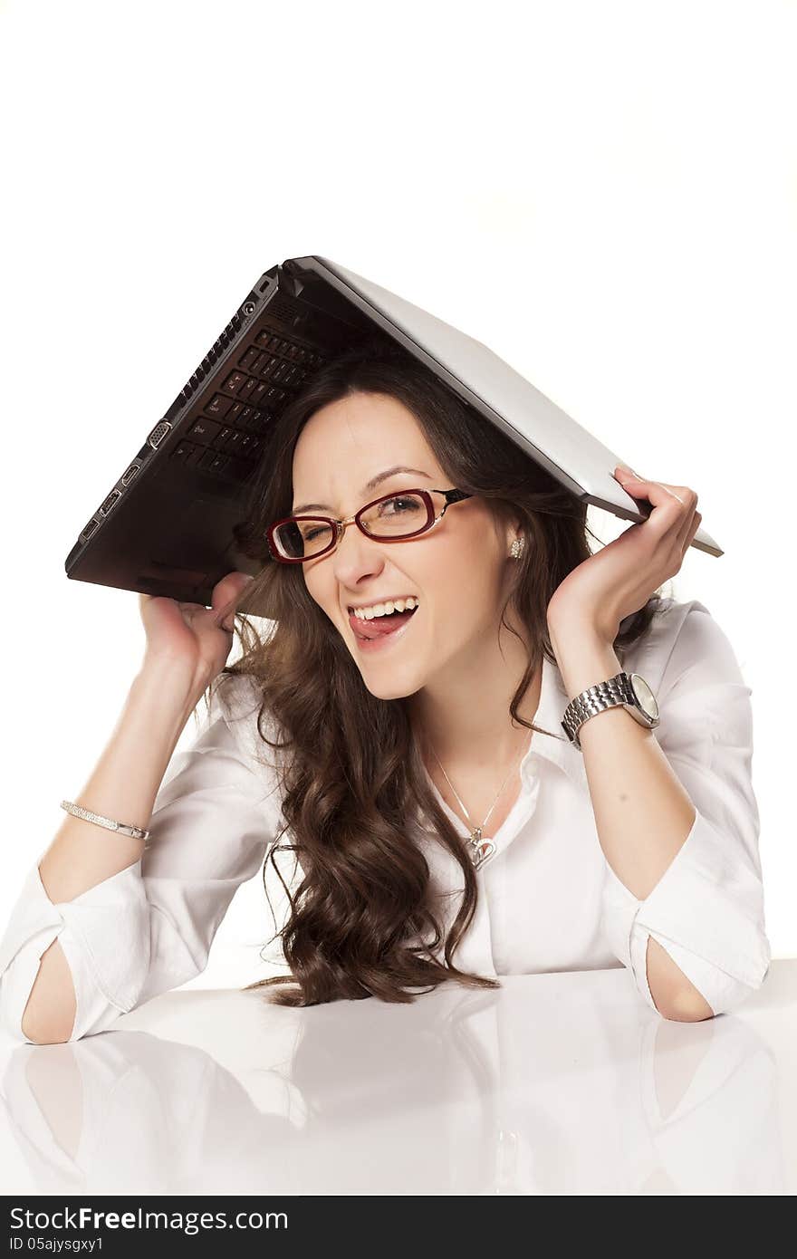 Smiling girl covers her head with a laptop on white background. Smiling girl covers her head with a laptop on white background