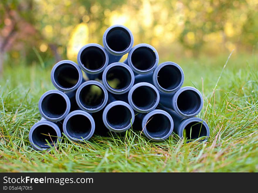 Pipes stacked on the grass in the garden. Pipes stacked on the grass in the garden