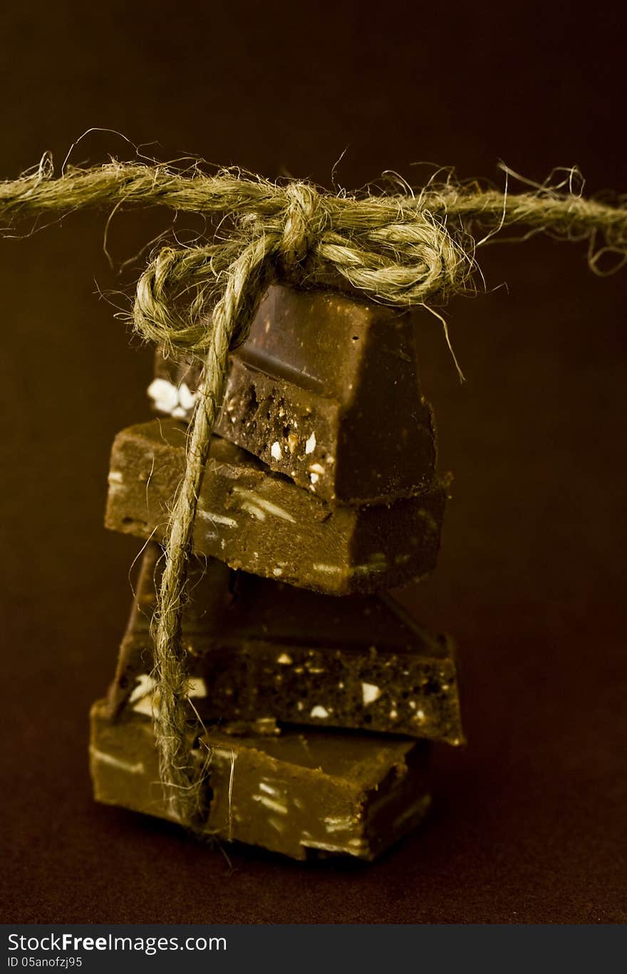 Chocolate pieces with natural twine on dark background