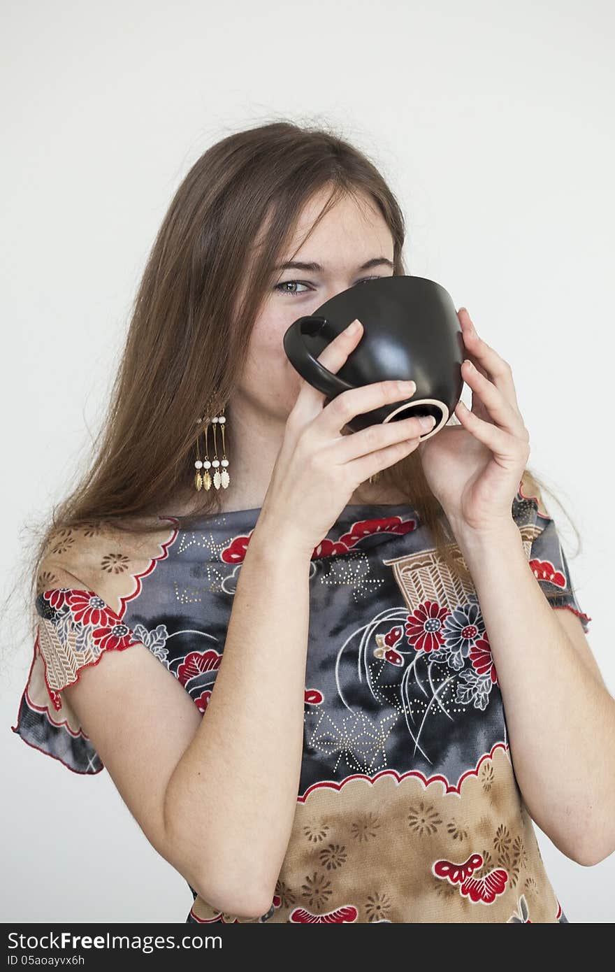 Portrait of a young woman with a black coffee cup looking directly at the camera. Portrait of a young woman with a black coffee cup looking directly at the camera