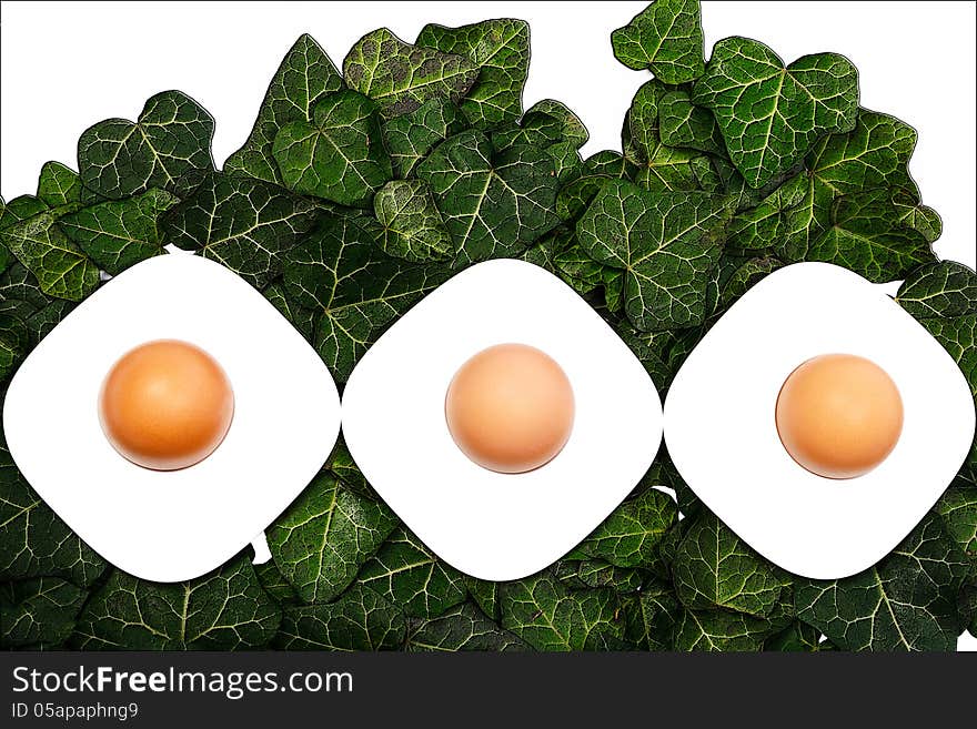 Three eggs and egg cups on a green background. Three eggs and egg cups on a green background