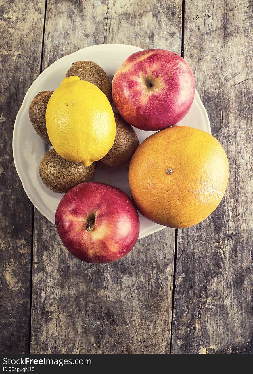 Various fruits on a plate on old table,retro. Various fruits on a plate on old table,retro