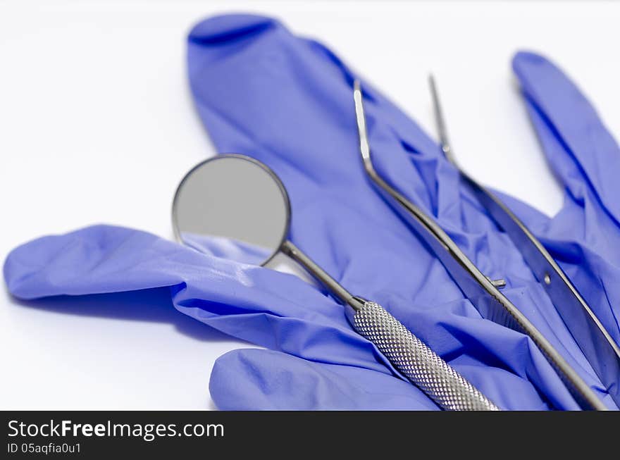 Dental mirror and tweezers on gloves