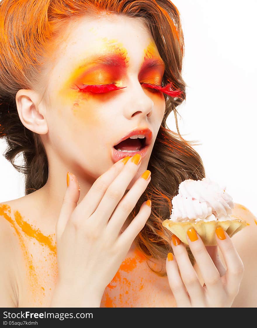 Gilding. Tempting Woman eating a Pie with Cream. Bright Red-Golden Makeup