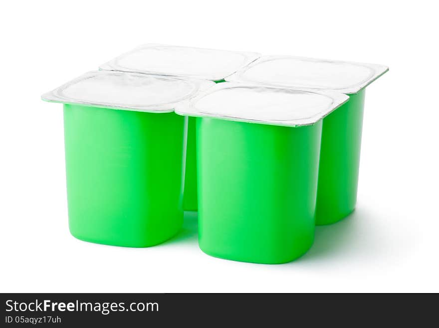 Four plastic containers for dairy products with foil lid. Standing on a white.