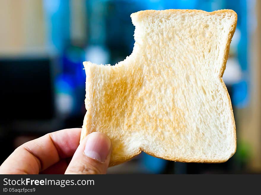 Hands holding toastwith a bite mark.