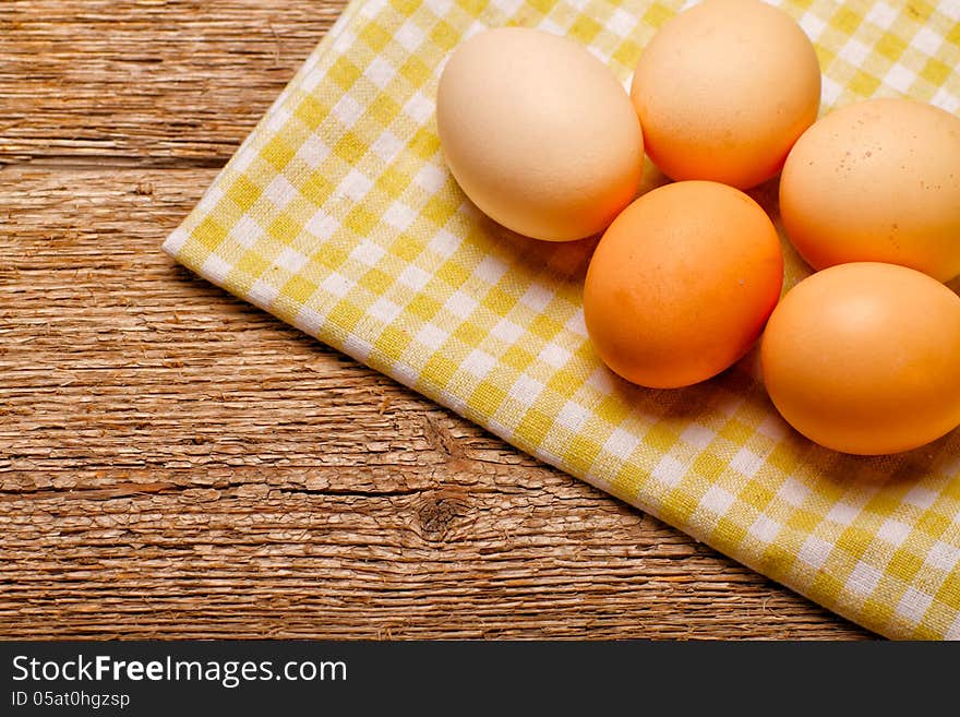 Eggs on rustic tablecloth over wooden background