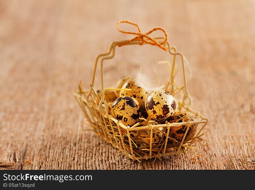 Quail eggs in vintage metal basket on wooden background. Quail eggs in vintage metal basket on wooden background