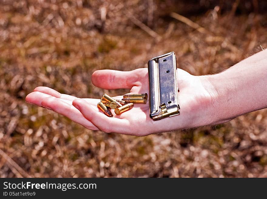 Girl holding bullets and clip while hunting.