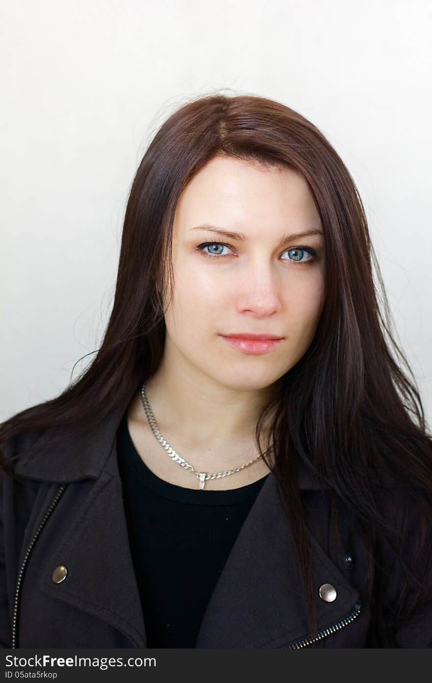 Serious beautiful brunette girl with long hair and calm strictly looking at the camera. Serious beautiful brunette girl with long hair and calm strictly looking at the camera