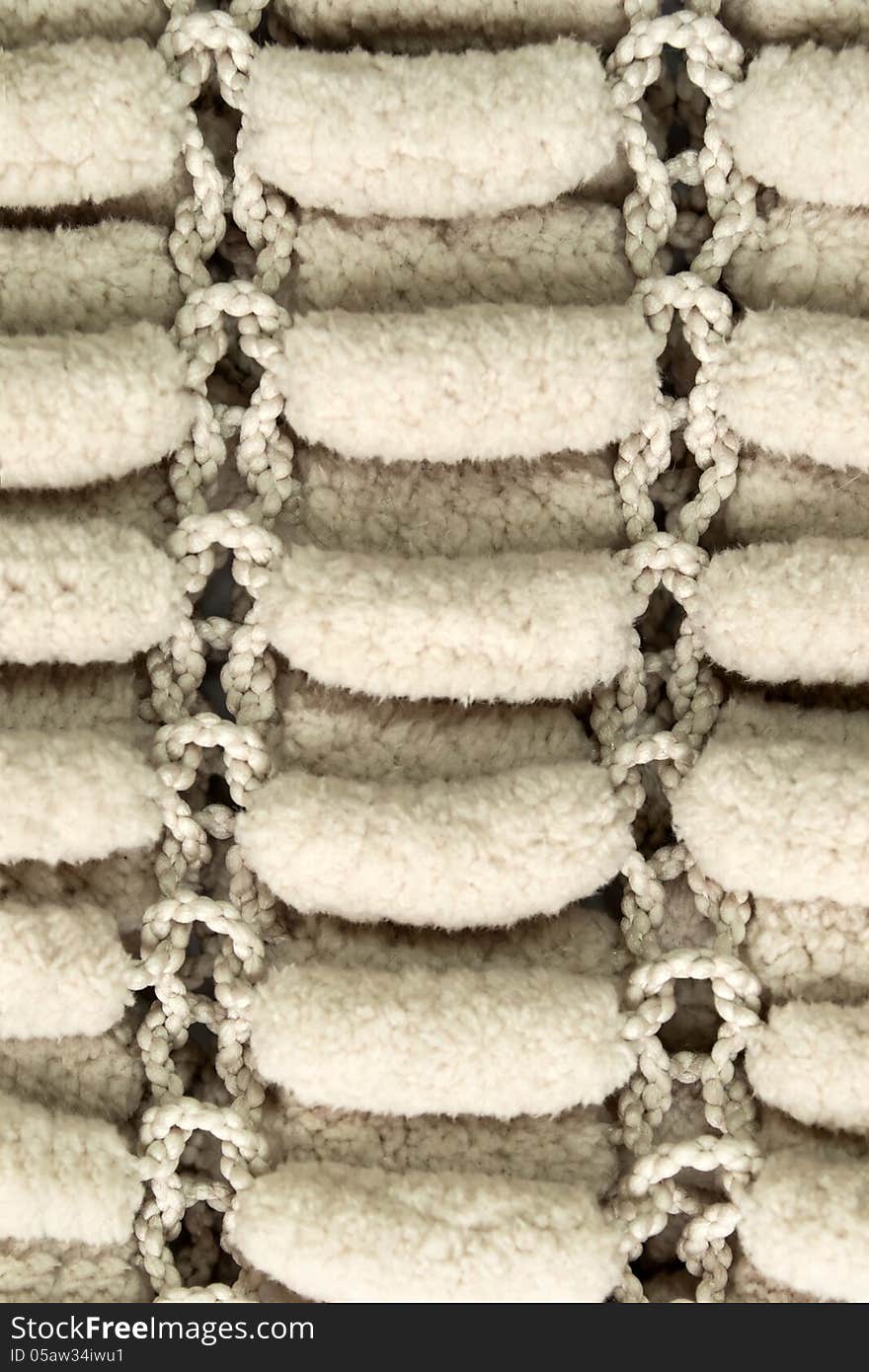 Beige plush pompons knitted background. Beige plush pompons knitted background