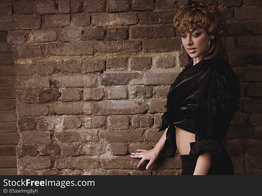 Beautiful woman leaning on a brick wall. Beautiful woman leaning on a brick wall