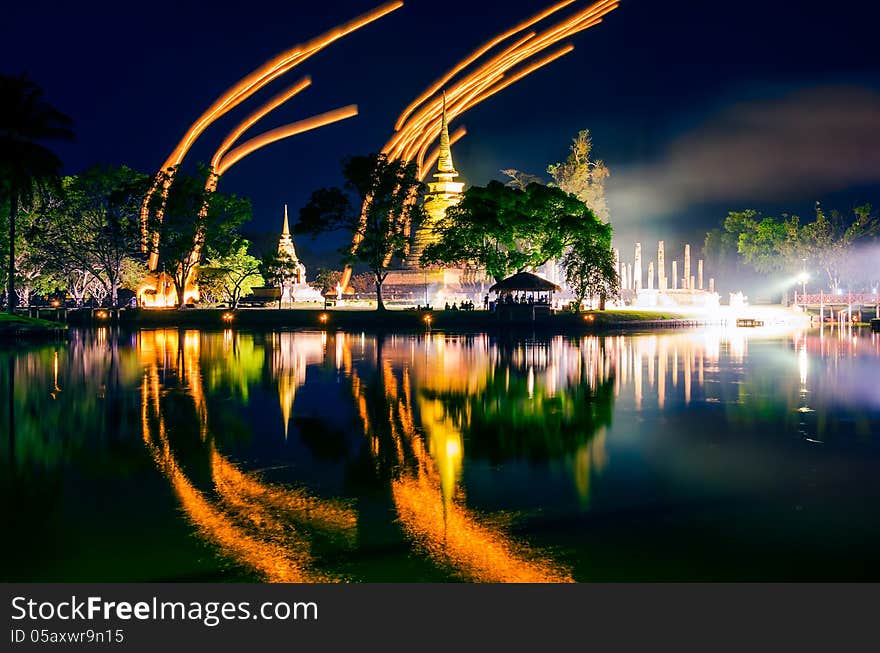 Light lampions at night above buddhist temple in Sukhothai historical park, Thailand