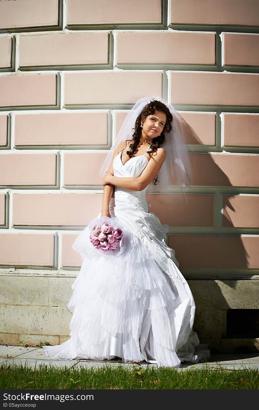 Elegant bride near ancient wall