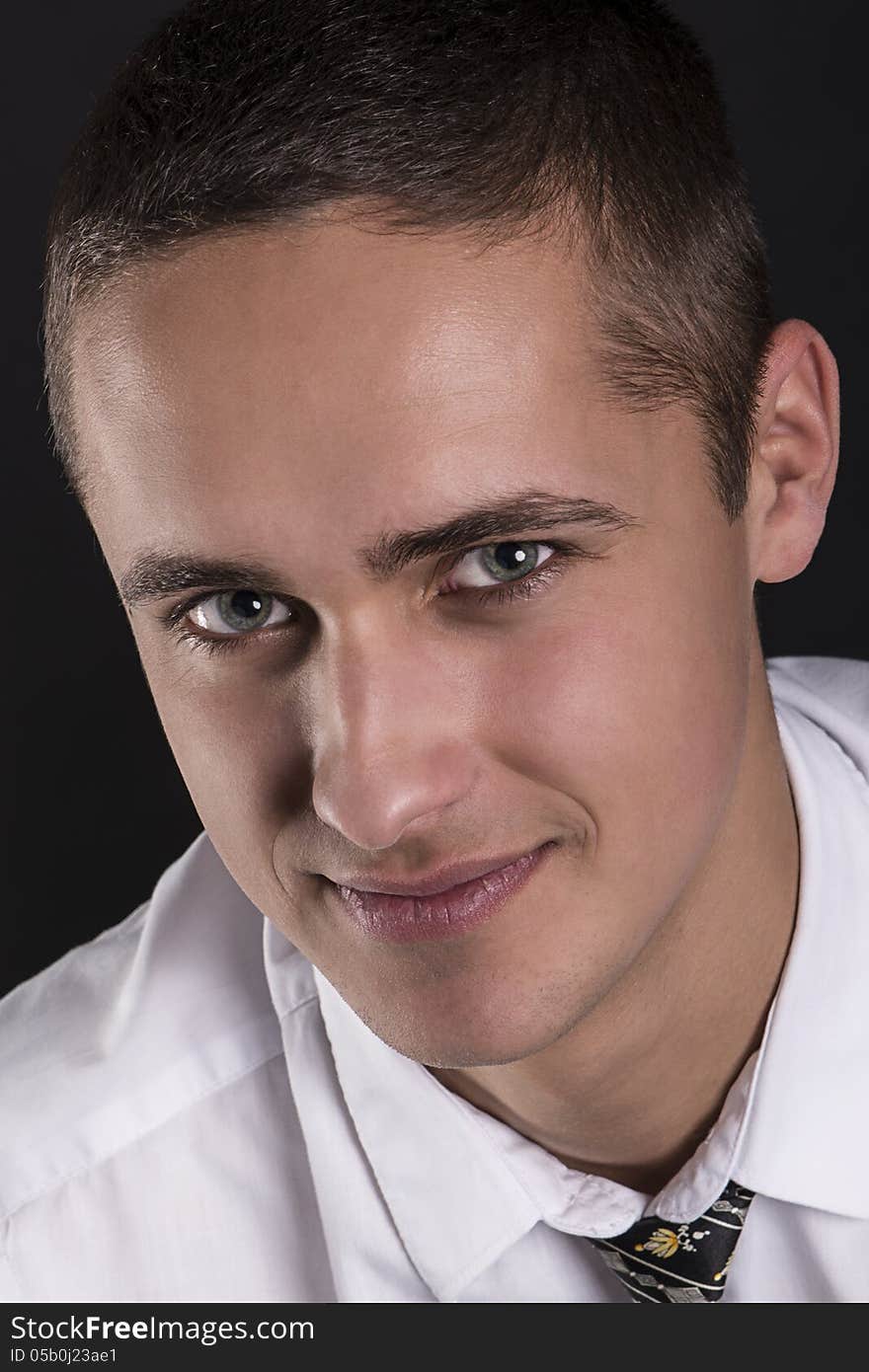 Close studio portrait of young charming man smiling and looking at you. Close studio portrait of young charming man smiling and looking at you