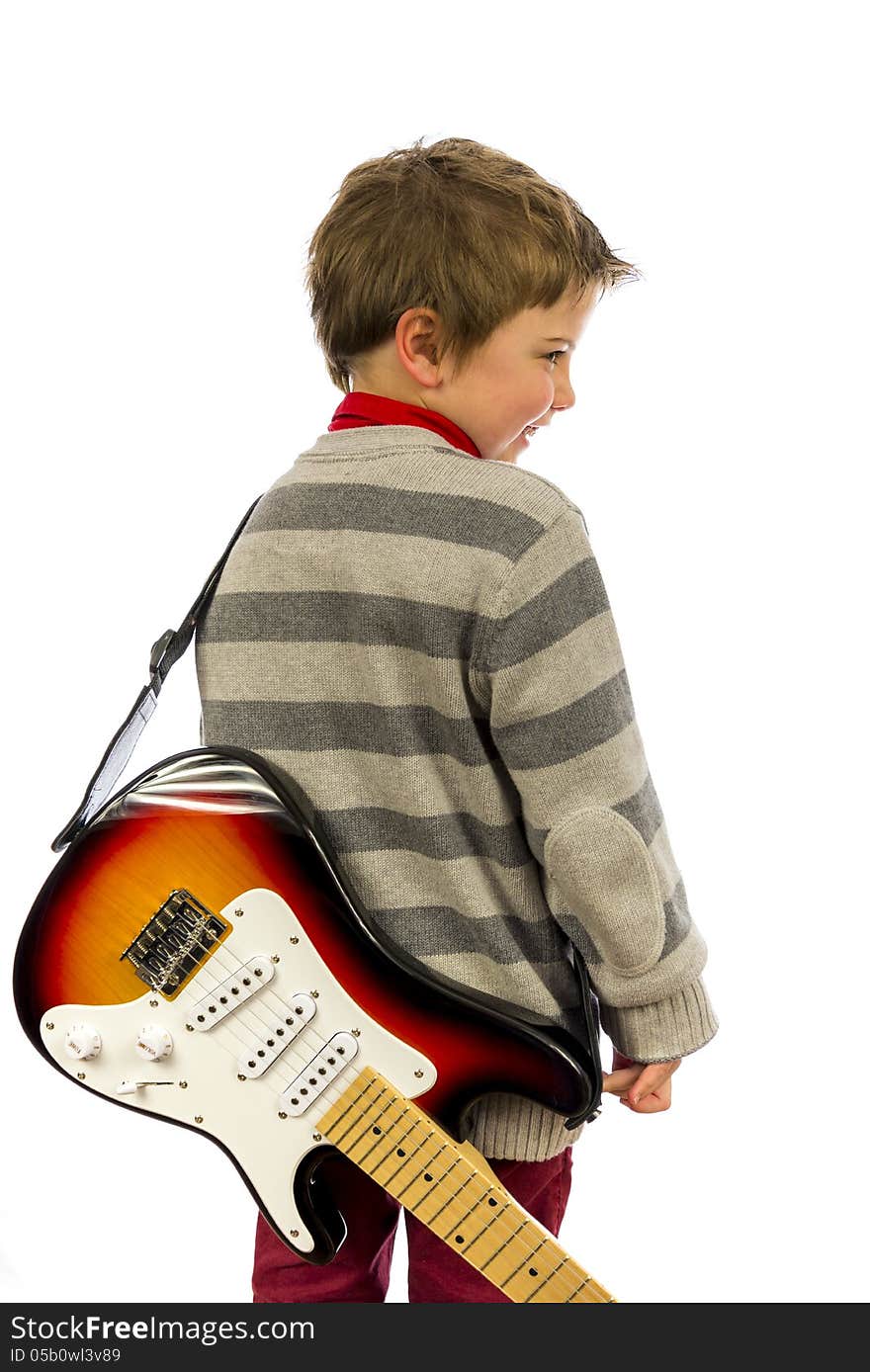 Boy with guitar on his back looking over shoulder. Boy with guitar on his back looking over shoulder.