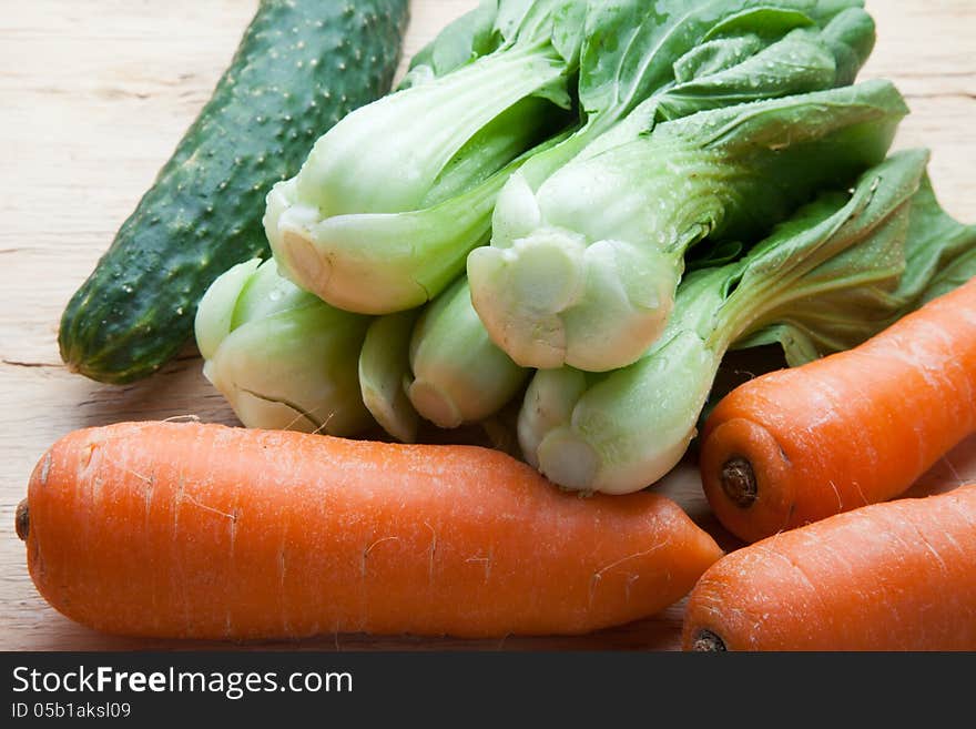 Green pakchoi and carrots on wood. Green pakchoi and carrots on wood