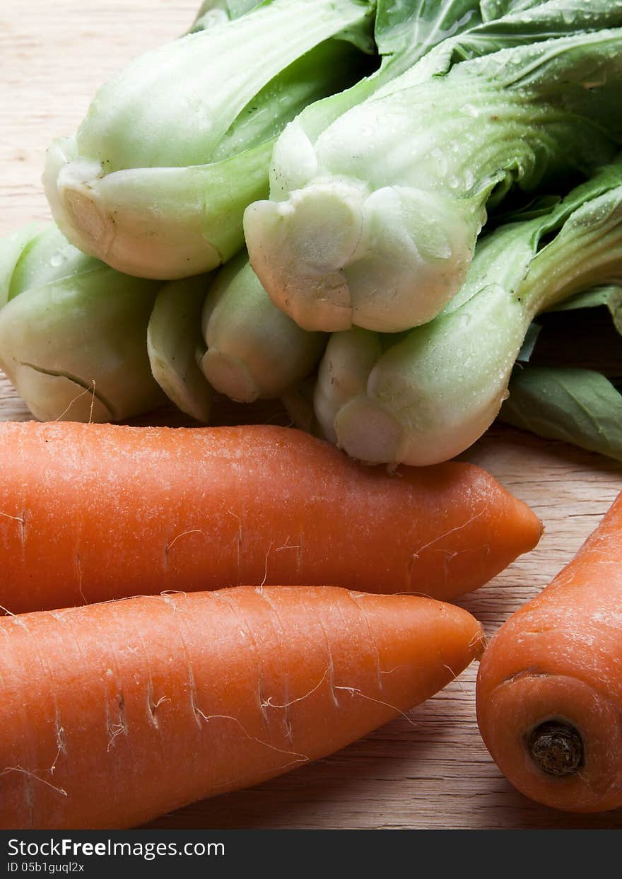 Green pakchoi and carrots on wood. Green pakchoi and carrots on wood