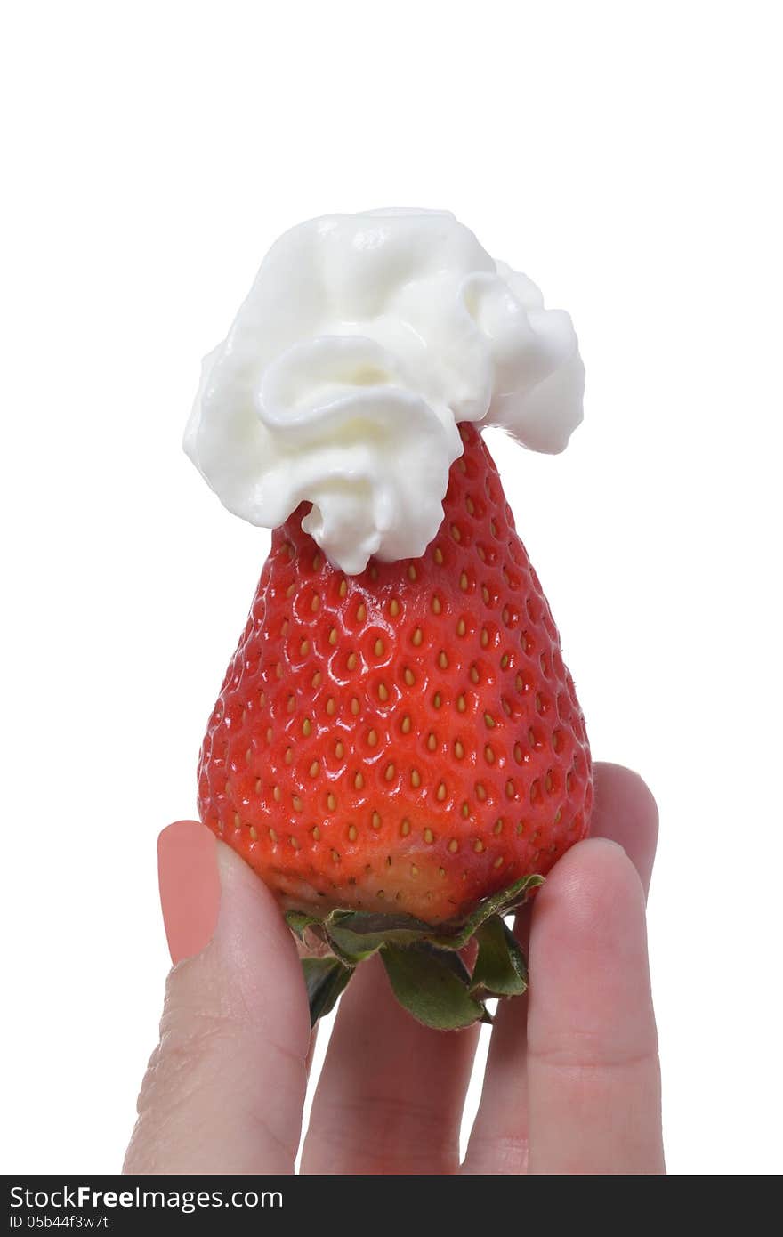 Fingers holding a strawberry with whipped cream. Fingers holding a strawberry with whipped cream