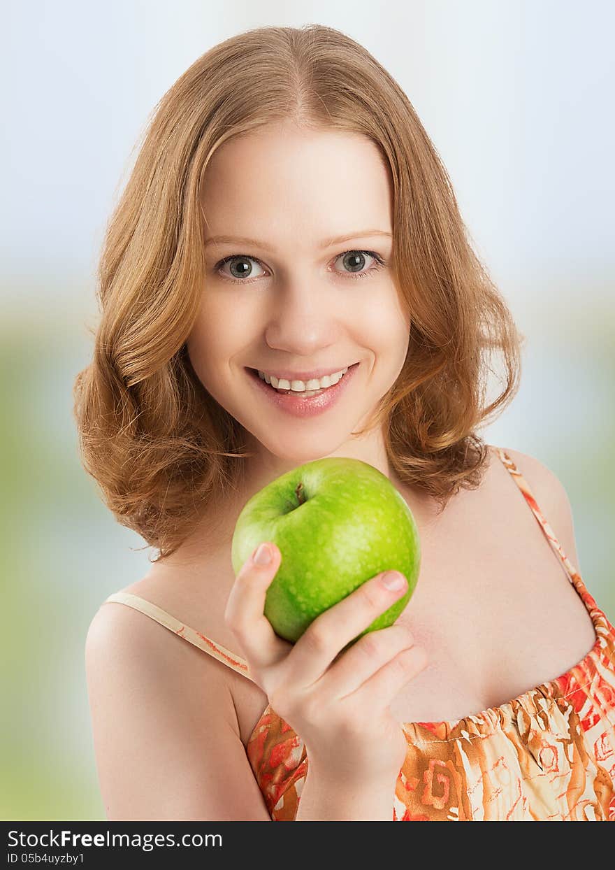 Young healthy woman eating fruit, green apple at home