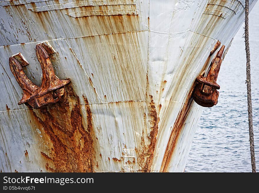 Front of an old rusty boat with anchor