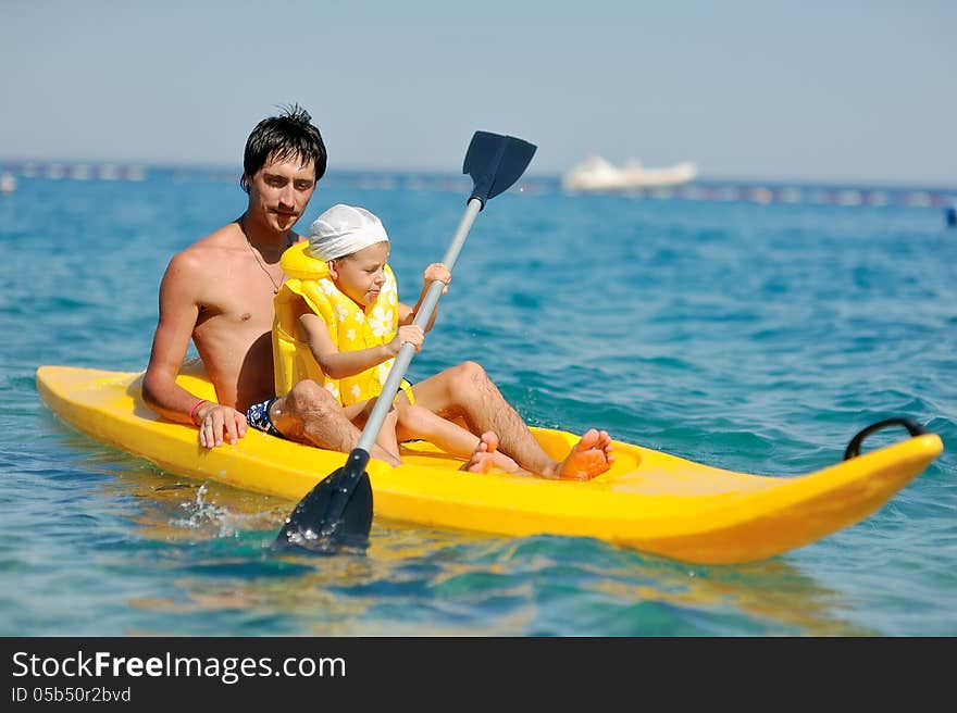 Little boy with his father in the yellow boat floating on the sea. Little boy with his father in the yellow boat floating on the sea