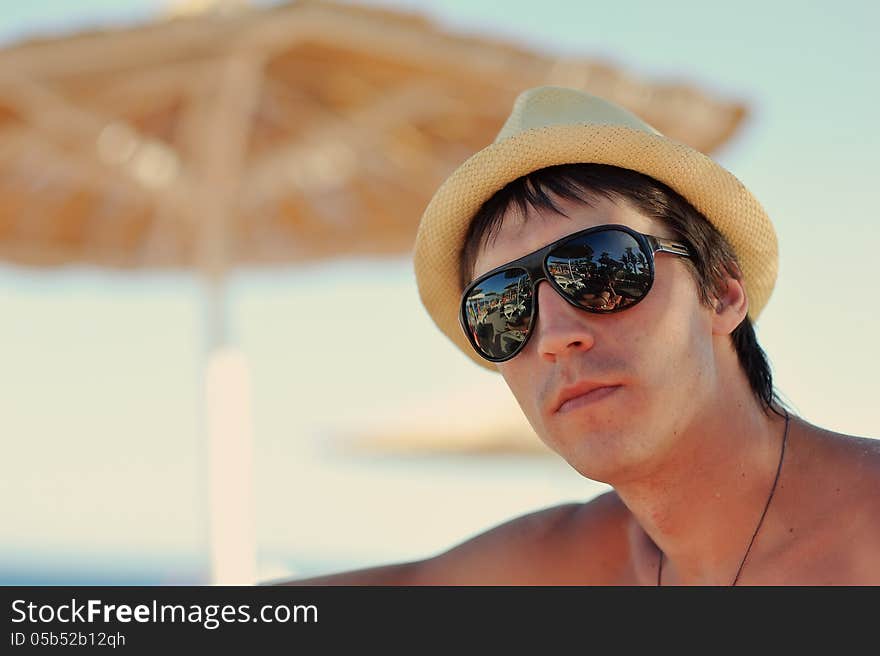 Portrait of a guy in a straw hat and black sunglasses. Portrait of a guy in a straw hat and black sunglasses