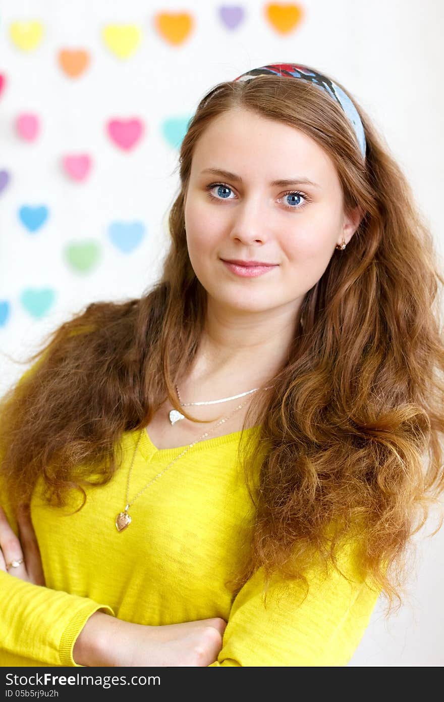 Portrait of a beautiful young cheerful brunette smiling girl with long red hair in the yellow blouse. Portrait of a beautiful young cheerful brunette smiling girl with long red hair in the yellow blouse