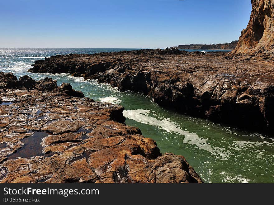 Mountains and lava field with waves splashes at coastline