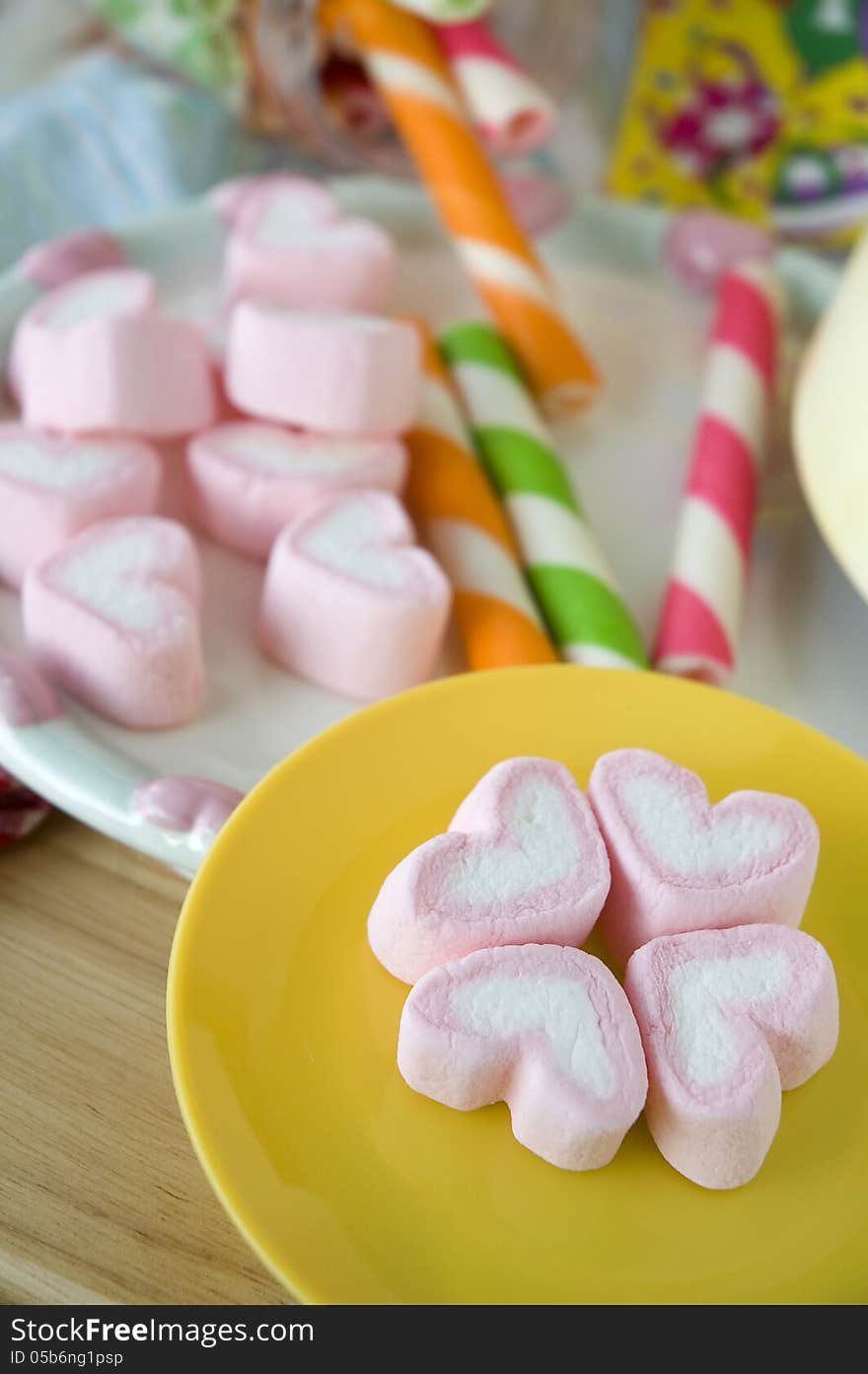 Pink heart marshmallow on yellow plate