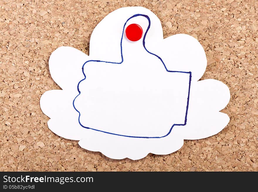 Cloud shape paper note with a like thumb drawing inside with a pen on a corkboard. Cloud shape paper note with a like thumb drawing inside with a pen on a corkboard.