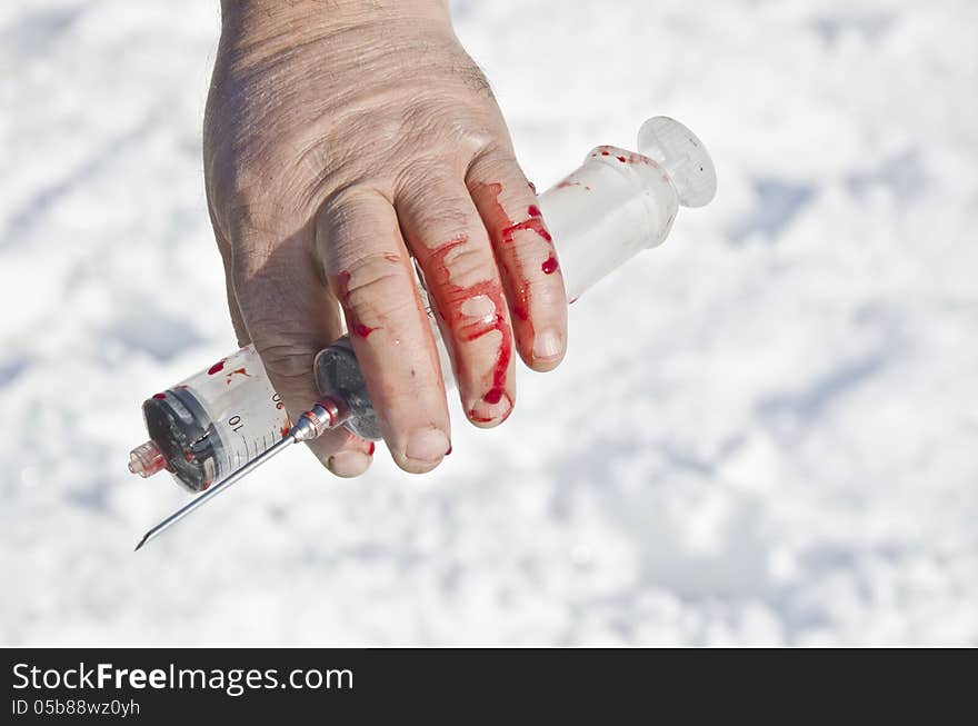 Bloody Hand Holding Syringes