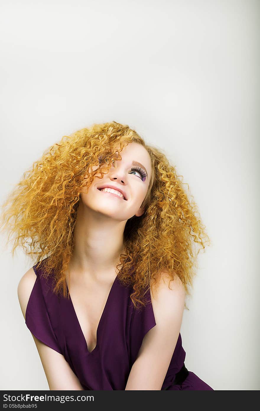 Lifestyle. Radiant Happy Woman with Curly Golden Hairs smiling. Positive Emotions