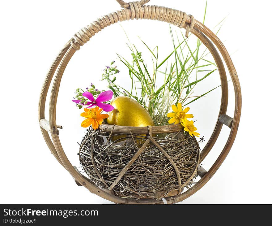 Golden Easter egg in the basket with flowers