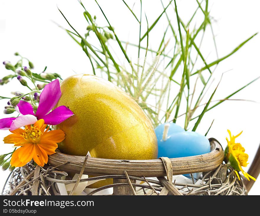 Golden Easter egg in the basket with flowers