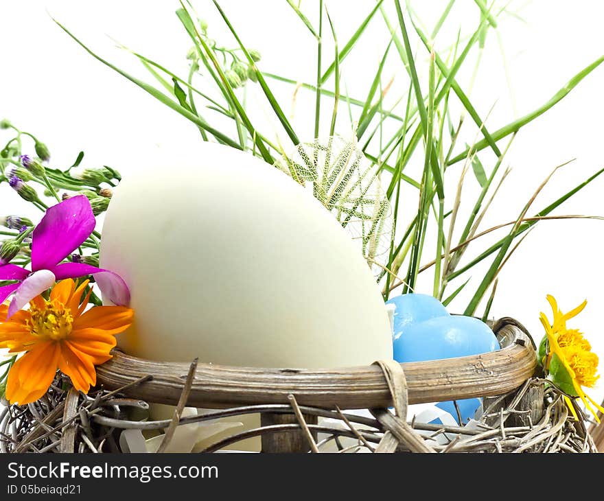 White Easter egg in the basket with flowers