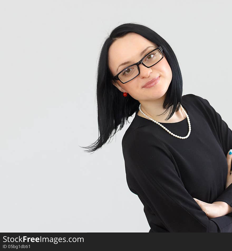 Serious brunette girl in a black dress and sunglasses with a short haircut calm strictly looking at the camera. Serious brunette girl in a black dress and sunglasses with a short haircut calm strictly looking at the camera