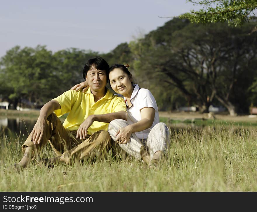 Portrait of beautiful couple sitting on ground in park relaxing. Portrait of beautiful couple sitting on ground in park relaxing