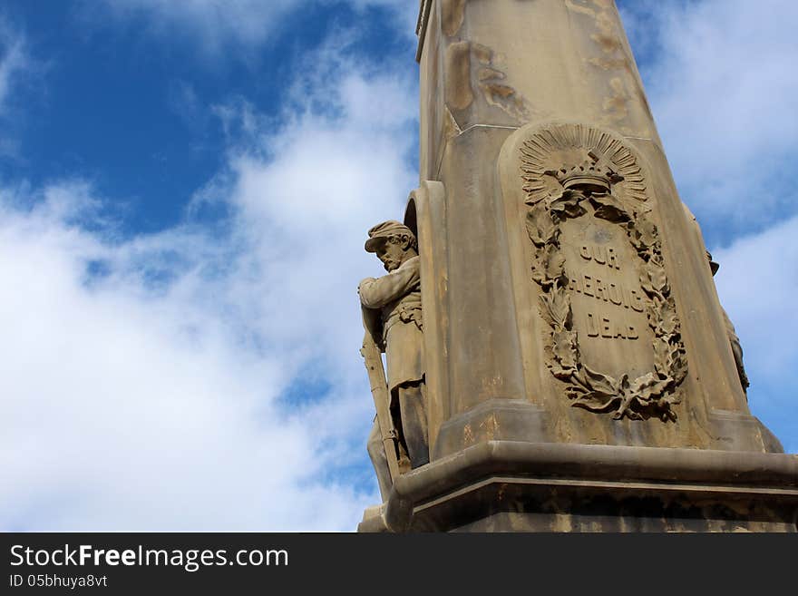 Stone war monument of soldier holding arms made in honor of all those that fought to be free.