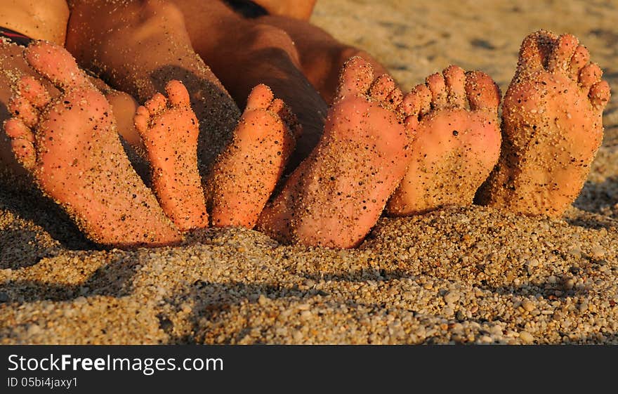 Soles of a family sitting on a pebble beach. Soles of a family sitting on a pebble beach