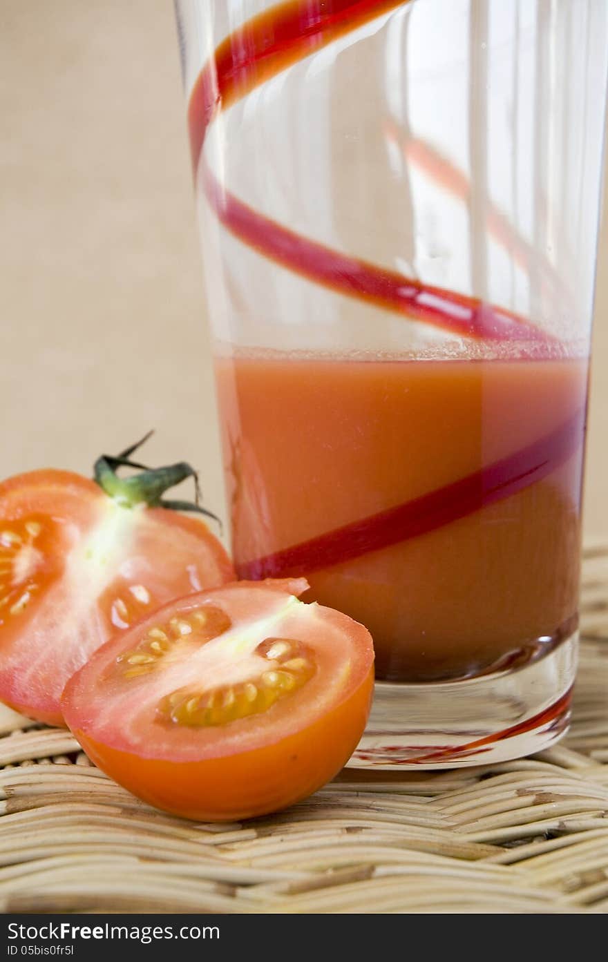 A glass of tomato juice with fresh tomato