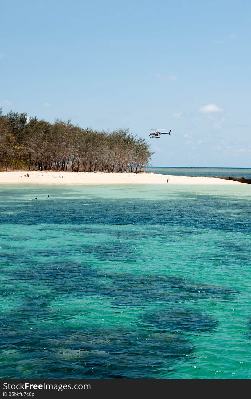 A helicopter lands on the beach at Green Island, near Cairns. A helicopter lands on the beach at Green Island, near Cairns